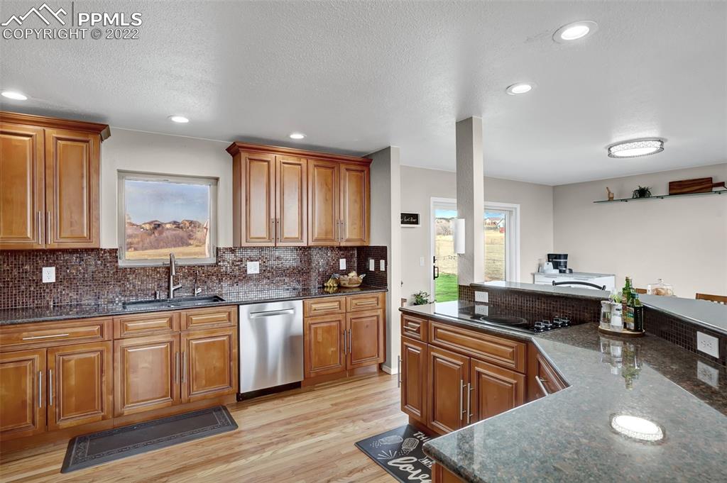 545 Struthers Loop Colorado Springs, CO 80921 - Photo 20 of 44 a kitchen with stainless steel appliances granite countertop a sink stove and cabinets