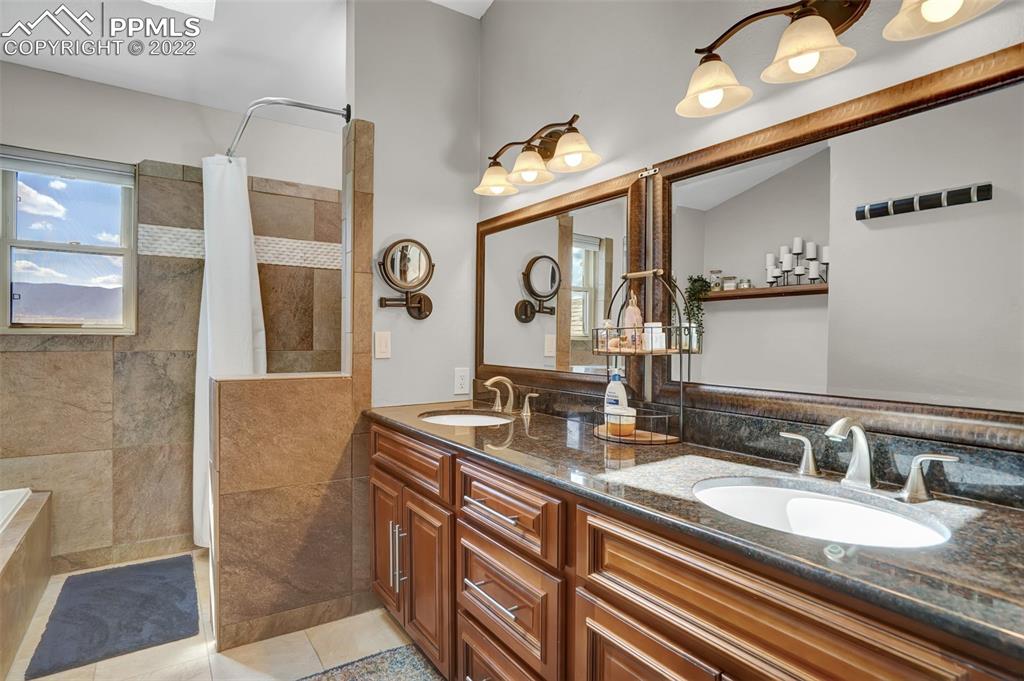 545 Struthers Loop Colorado Springs, CO 80921 - Photo 26 of 44 a bathroom with a granite countertop double vanity sink and a mirror
