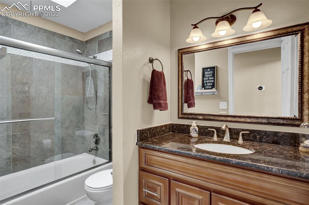 545 Struthers Loop Colorado Springs, CO 80921 - Photo 30 of 44 a bathroom with a granite countertop sink a mirror and shower