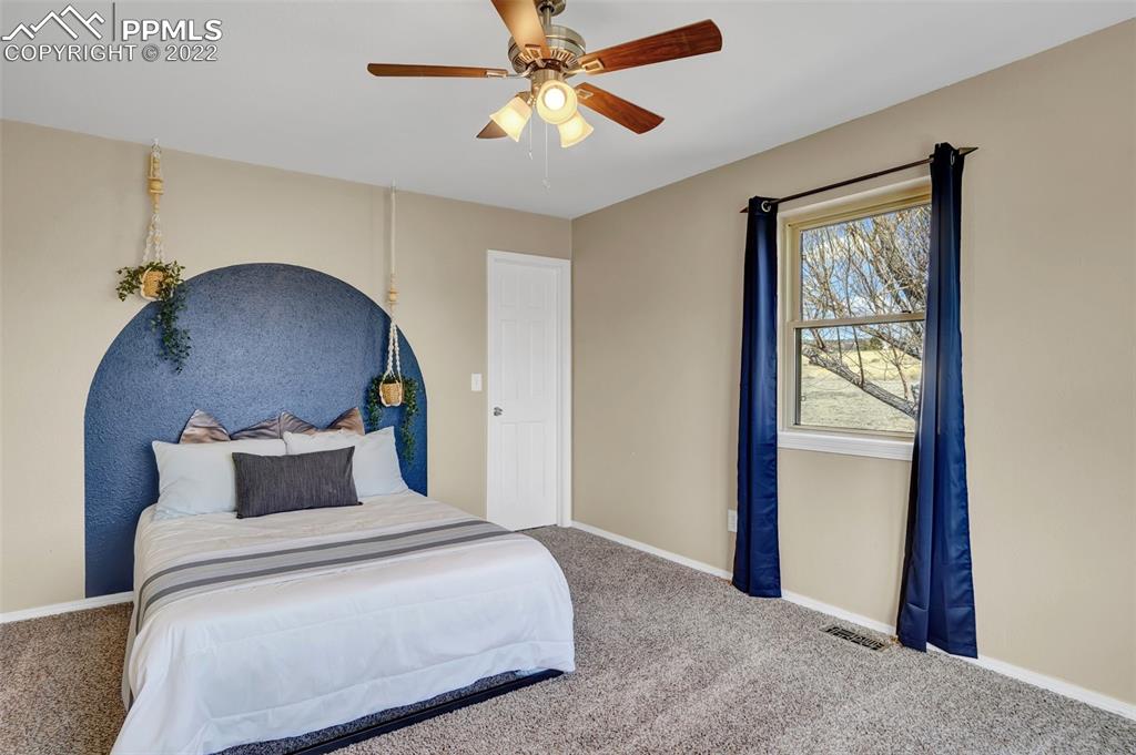 545 Struthers Loop Colorado Springs, CO 80921 - Photo 31 of 44 a bedroom with a bed and a chandelier