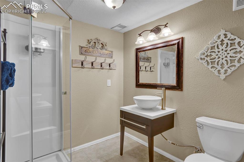 545 Struthers Loop Colorado Springs, CO 80921 - Photo 38 of 44 a bathroom with a toilet sink and mirror