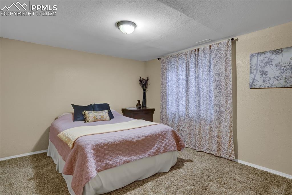 545 Struthers Loop Colorado Springs, CO 80921 - Photo 39 of 44 a bedroom with a bed and a painting on the wall