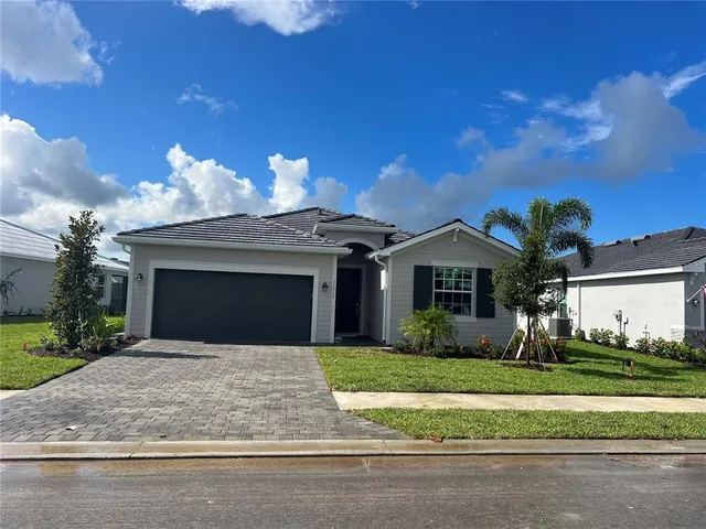 a front view of a house with a yard garage and outdoor seating