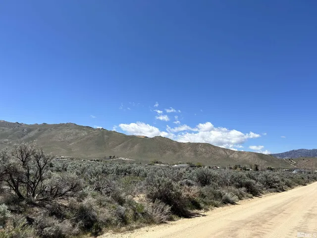 a view of a mountain range with a lush green hillside