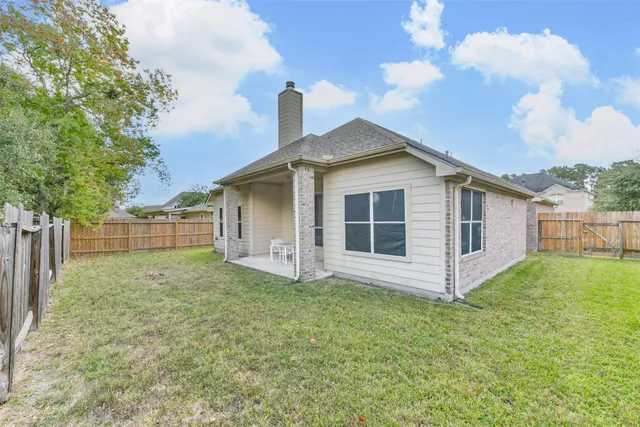 a view of a house with a yard and fence