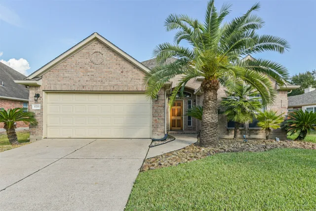 front view of house with a yard and potted plants