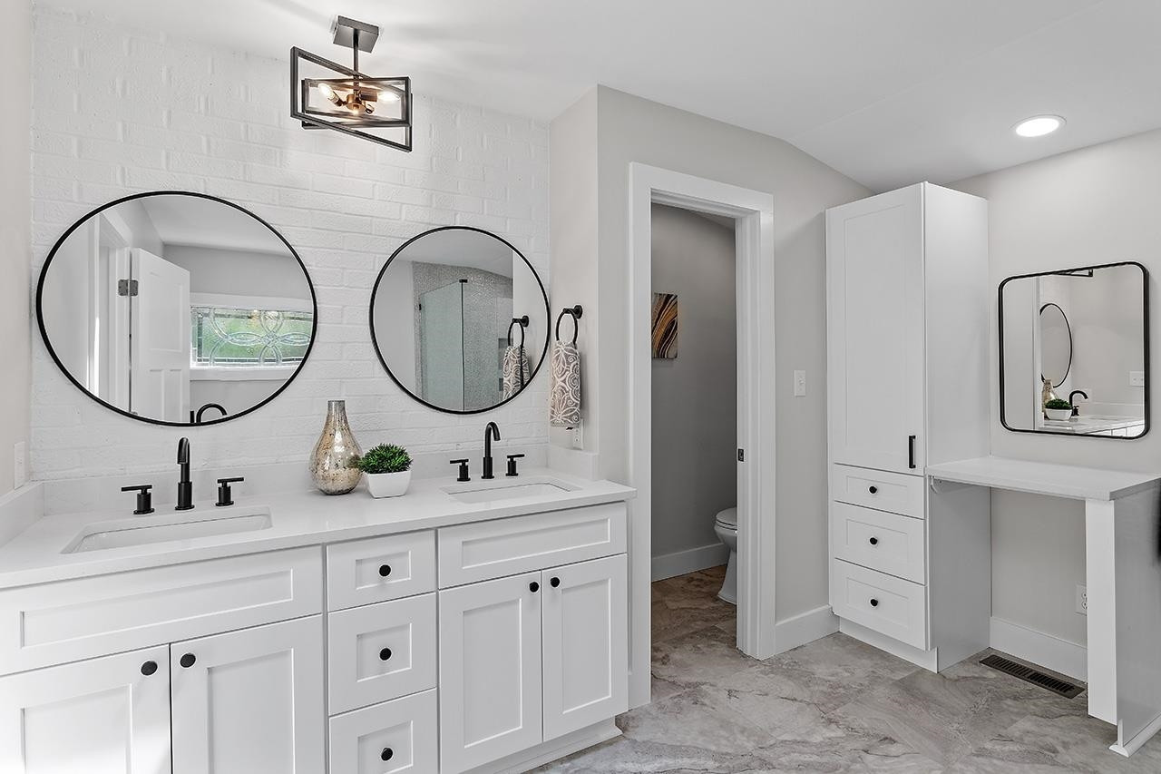 3420 East Garner Road Clayton, NC 27520 - Photo 19 of 30 a bathroom with a double vanity sink and a mirror