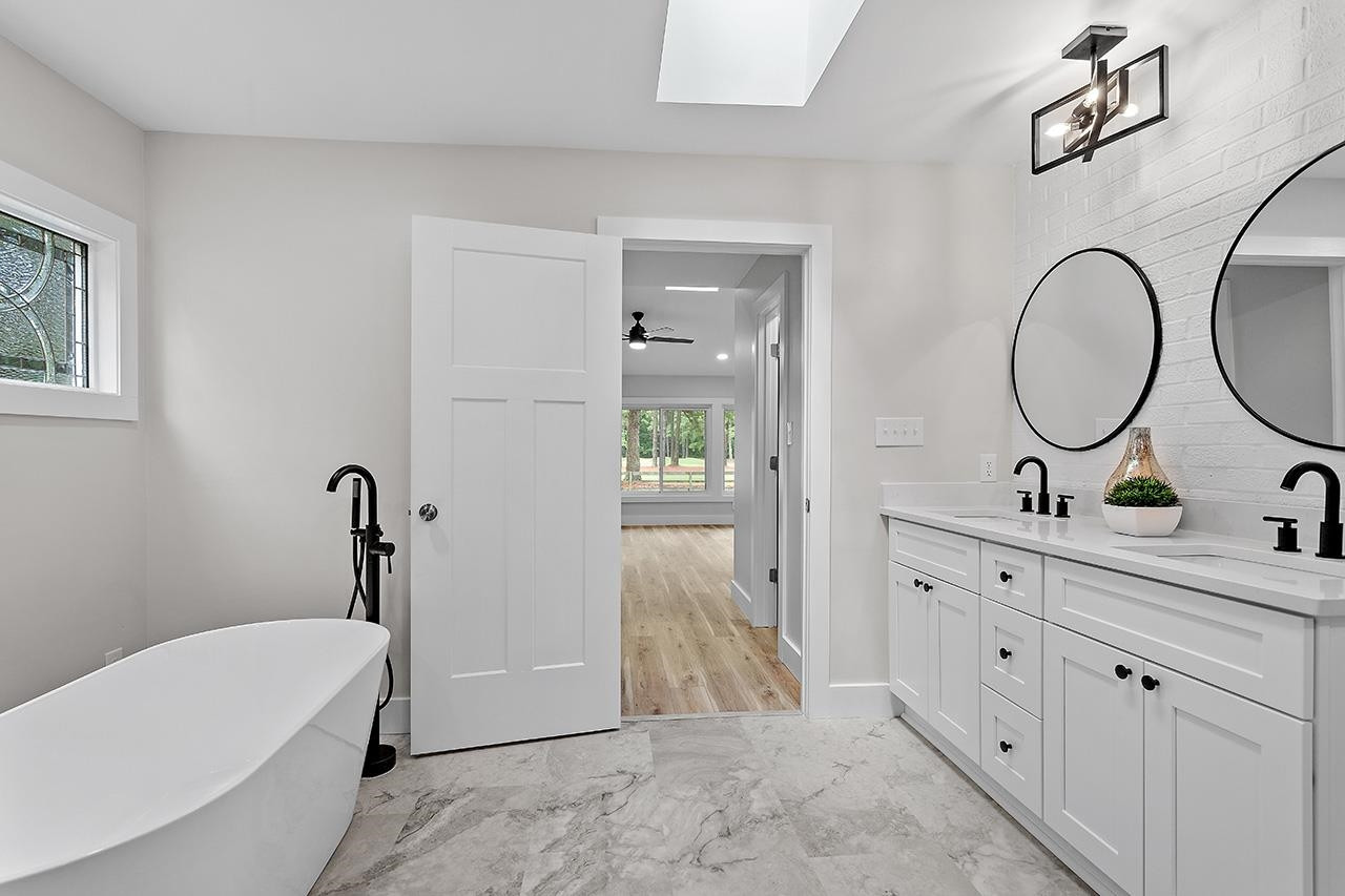 3420 East Garner Road Clayton, NC 27520 - Photo 20 of 30 a spacious bathroom with a tub sink and mirror