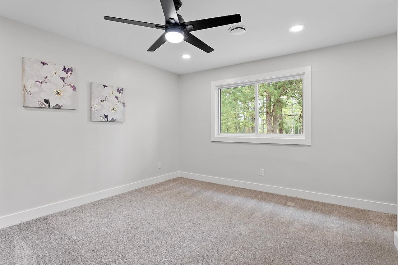3420 East Garner Road Clayton, NC 27520 - Photo 22 of 30 an empty room with a window and a fan