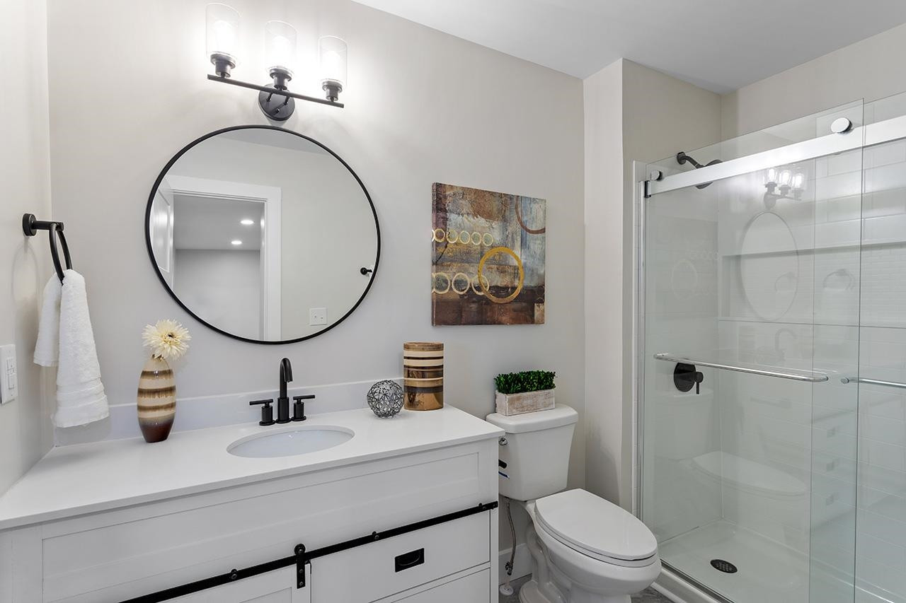 3420 East Garner Road Clayton, NC 27520 - Photo 23 of 30 a bathroom with a sink mirror toilet and a mirror