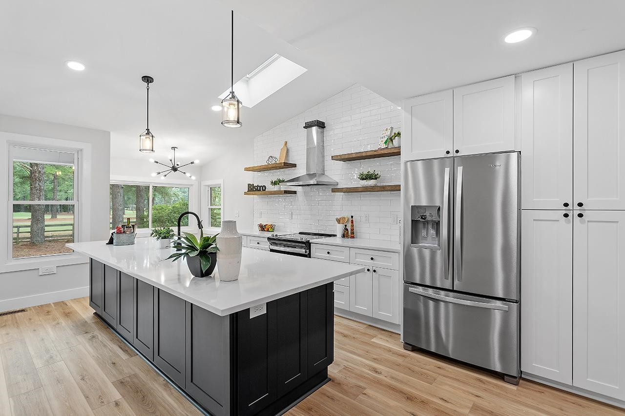 3420 East Garner Road Clayton, NC 27520 - Photo 6 of 30 a kitchen with kitchen island a counter space a sink appliances and cabinets