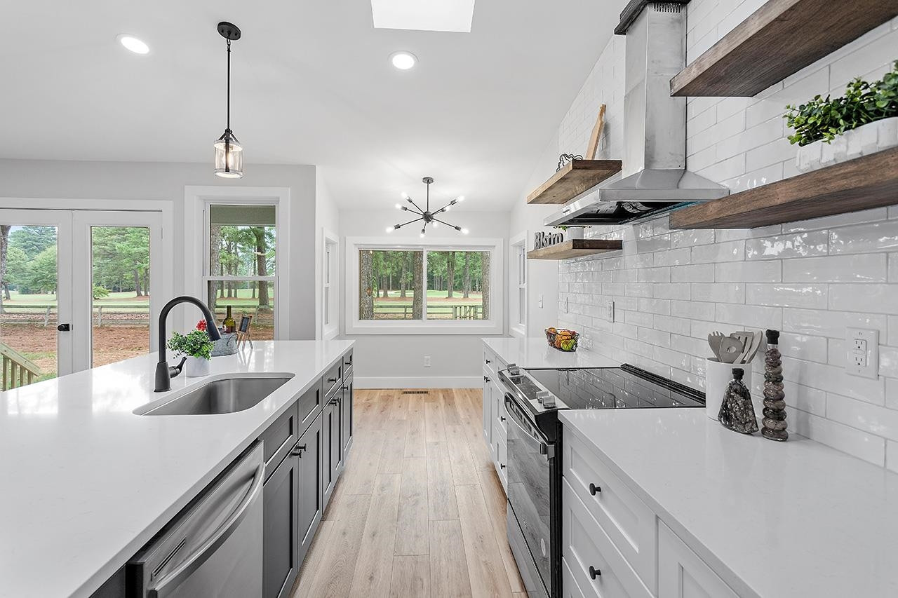 3420 East Garner Road Clayton, NC 27520 - Photo 7 of 30 a kitchen that has a sink and a stove with wooden floor