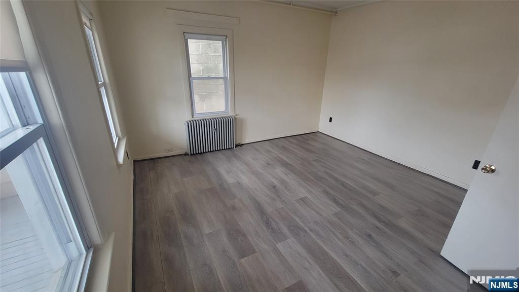 90 Ackerson Street, Unit 1 Hackensack, NJ 07601 - Photo 12 of 14 an empty room with wooden floor and windows