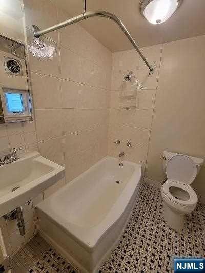 90 Ackerson Street, Unit 1 Hackensack, NJ 07601 - Photo 14 of 14 a bathroom with a sink a toilet and shower