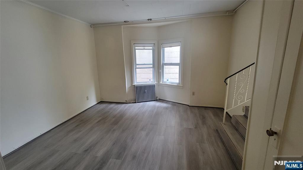90 Ackerson Street, Unit 1 Hackensack, NJ 07601 - Photo 9 of 14 an empty room with wooden floor and windows