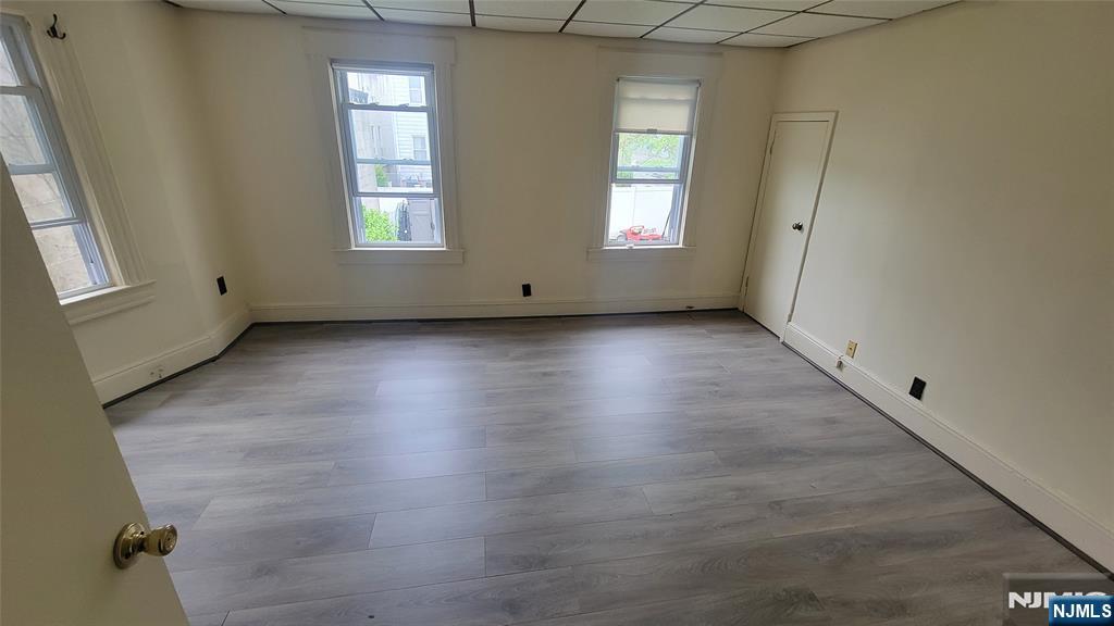 90 Ackerson Street, Unit 1 Hackensack, NJ 07601 - Photo 10 of 14 an empty room with wooden floor and windows