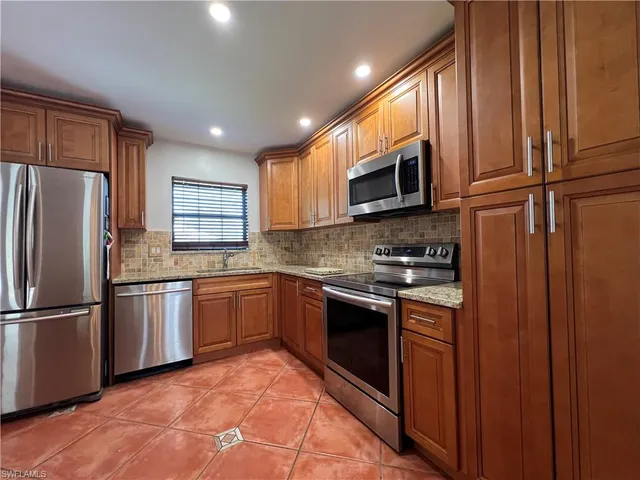 a kitchen with stainless steel appliances granite countertop a stove a sink and a refrigerator