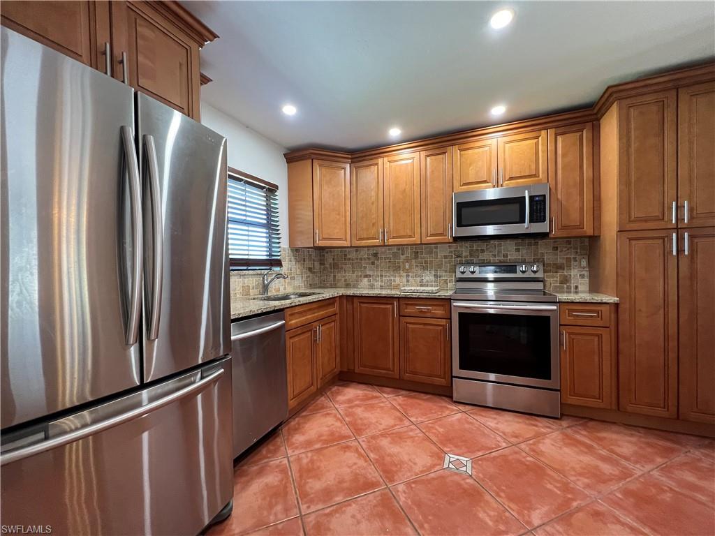 4724 32nd Avenue Southwest Naples, FL 34116 - Photo 19 of 39 a kitchen with stainless steel appliances a refrigerator sink and microwave