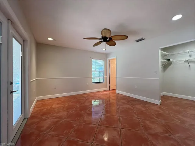 a view of a livingroom with a chandelier fan and kitchen view