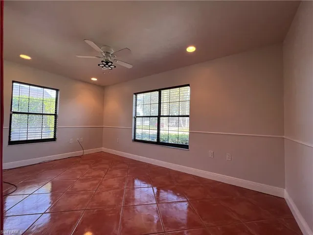 an empty room with fan and windows