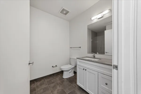 a bathroom with a granite countertop sink a toilet and a mirror