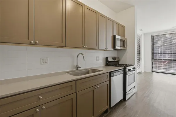 a kitchen with stainless steel appliances granite countertop a sink a stove and cabinets