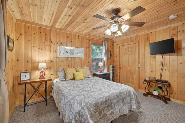 a bedroom with a bed and a flat tv screen on the dresser