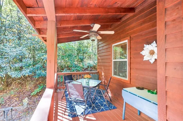 a view of a patio with table and chairs with wooden floor and fence