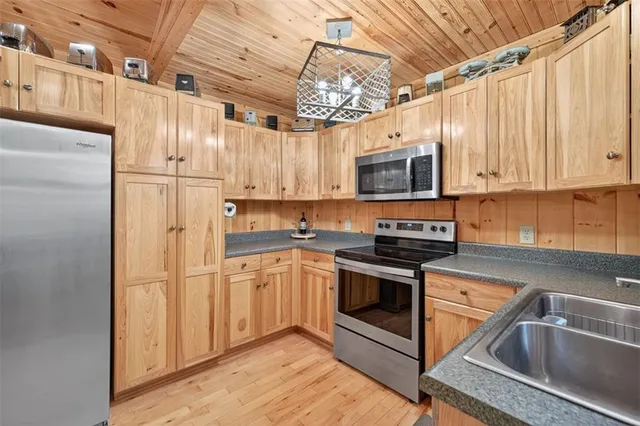 a kitchen with stainless steel appliances granite countertop a refrigerator a stove top oven a sink and dishwasher