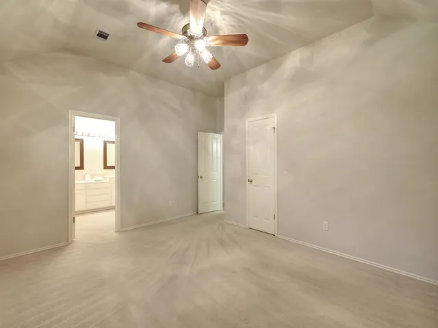 an empty room with fan and entrance