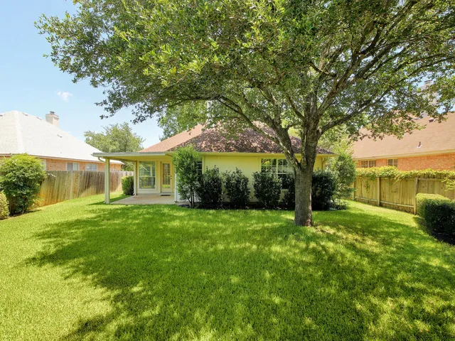 a view of a big yard with plants and large trees