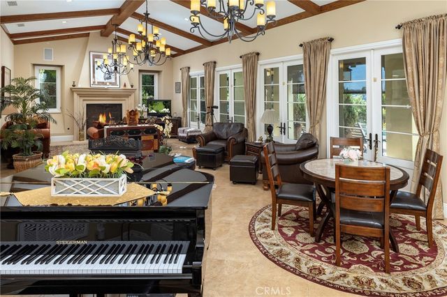 a living room with furniture a fireplace and a chandelier