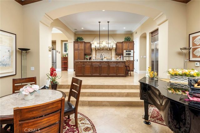 a view of a dining room with furniture a chandelier and wooden floor