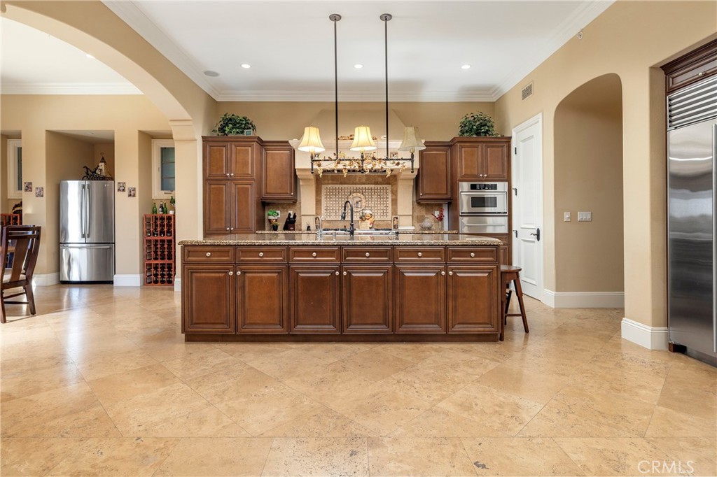 47 Vernal Irvine, CA 92603 - Photo 23 of 38 a kitchen with kitchen island granite countertop a stove a sink a refrigerator and a wooden cabinets