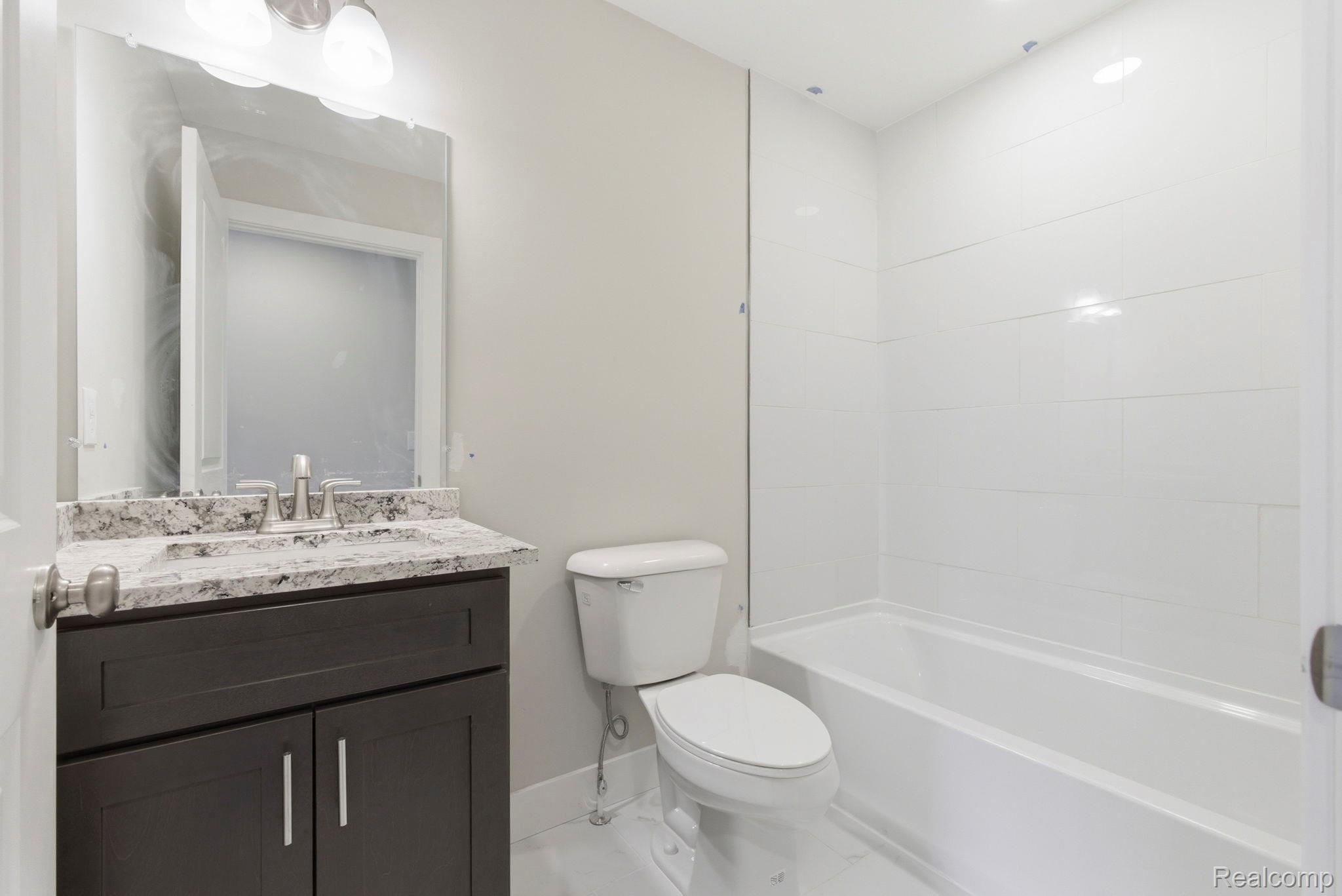 2361 Baltimore Davison, MI 48423 - Photo 21 of 31 Bathroom featuring vanity, bathtub / shower combination, and light marble finish flooring