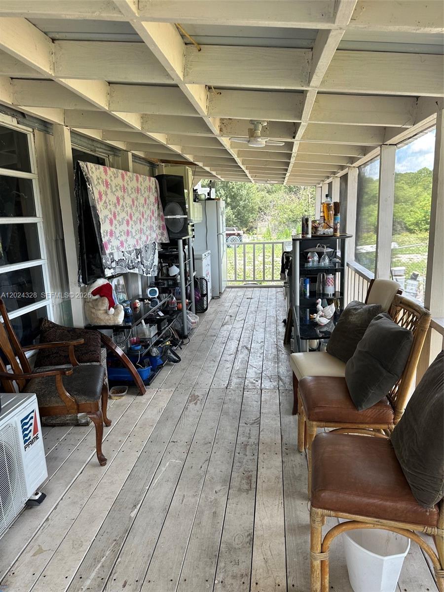 625 North Quebrada Street Clewiston, FL 33440 - Photo 15 of 26 a living room with furniture a flat screen tv and a floor to ceiling window