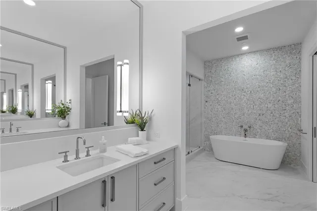 a bathroom with a double vanity sink mirror and bathtub