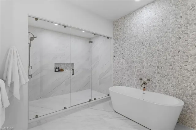 a white bath tub sitting next to a shower