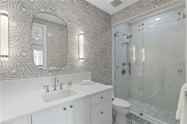 a bathroom with a double vanity sink mirror and toilet