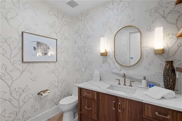 a bathroom with a toilet a sink and a mirror