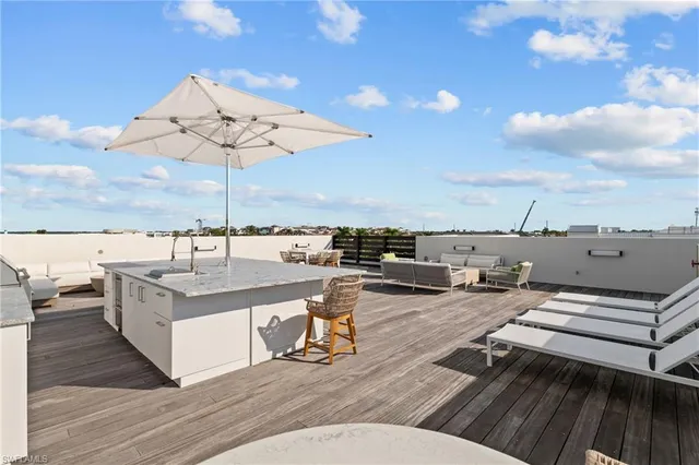 a living room with furniture a flat screen tv and kitchen view