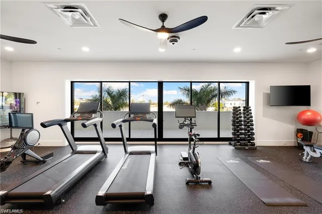 a living room with furniture a flat screen tv and a large window