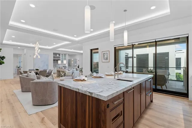 a dining hall with stainless steel appliances kitchen island granite countertop a sink and cabinets