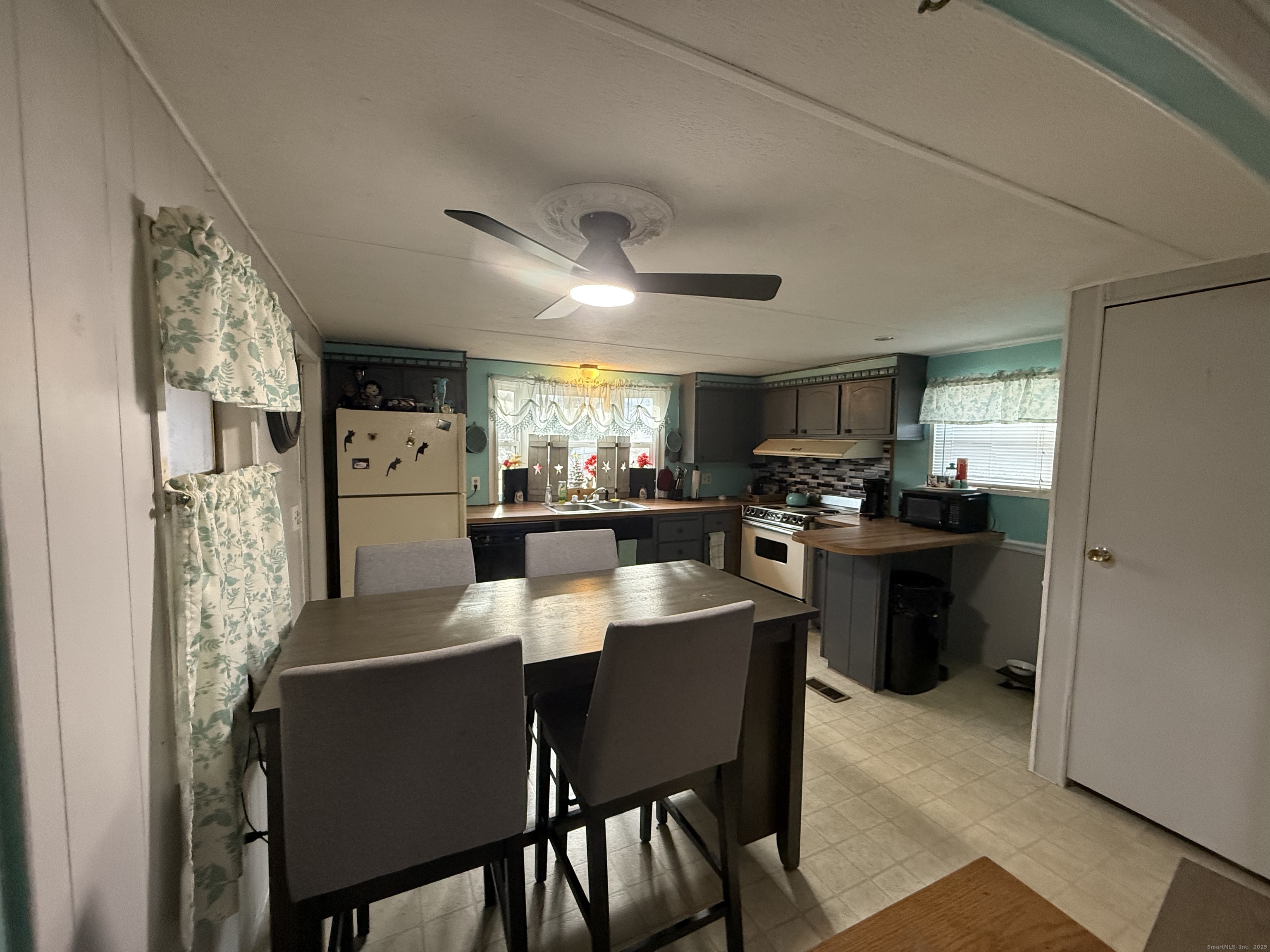 4 Sunshine Terrace Thompson, CT 06255 - Photo 11 of 25 a kitchen with a dining table chairs and refrigerator