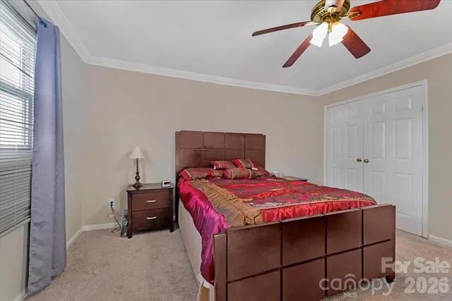 a bedroom with a bed and a chandelier fan
