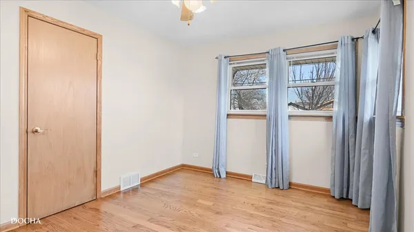 a view of empty room with wooden floor and windows