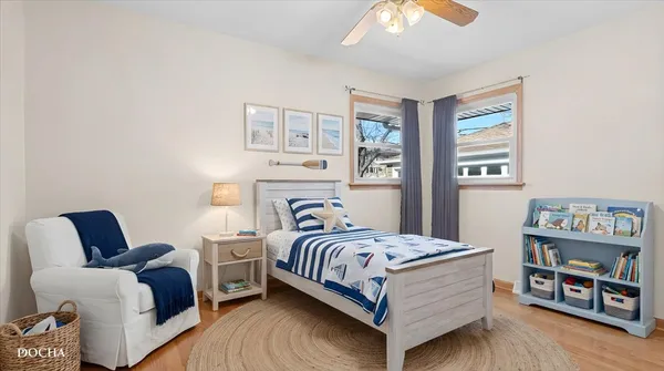 a bedroom with a bed wooden floor and window