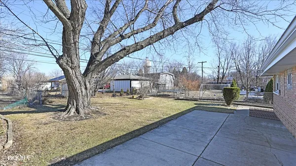 a view of a yard with wooden fence