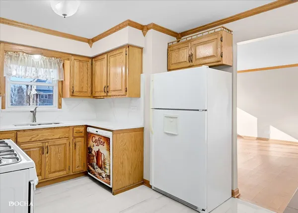 a kitchen with a refrigerator a sink and cabinets
