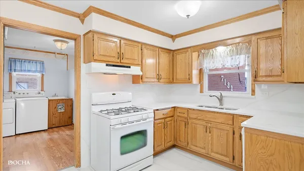 a kitchen with granite countertop a sink cabinets stainless steel appliances and a window